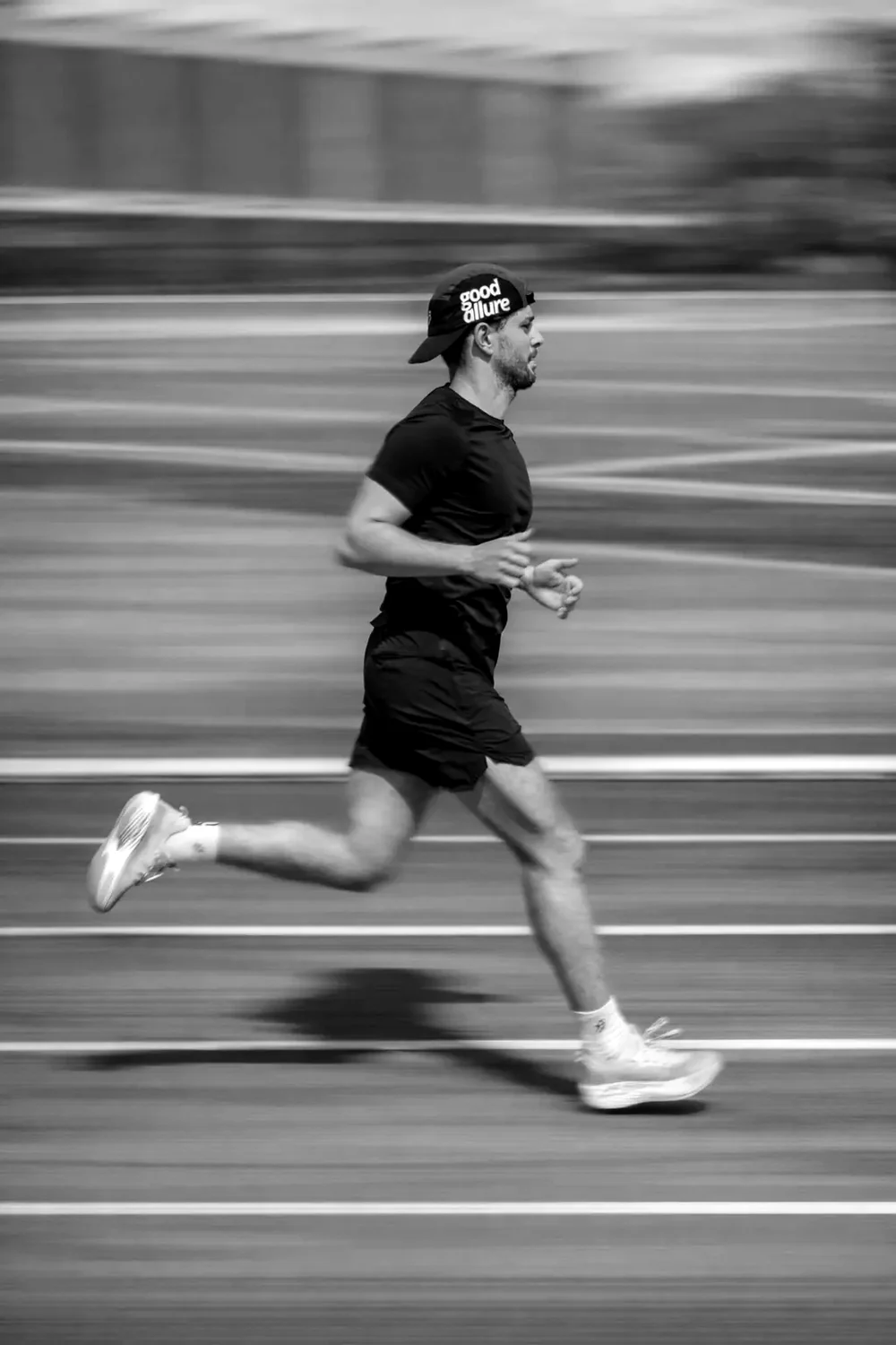 Un coureur lancé sur une piste, casquette GOOD ALLURE